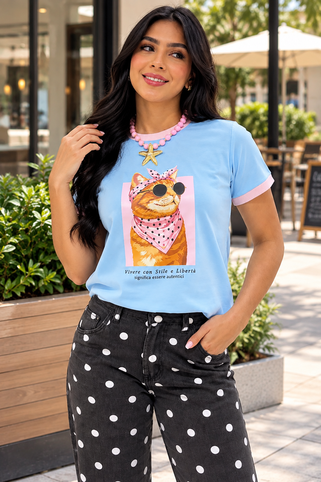 Camiseta azul claro de mujer con gatito estampado, gafas de sol y detalles rosados en cuello y mangas